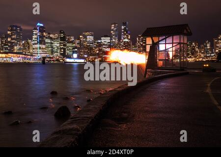 Vancouver 9 O'Clock Gun im Dunkeln mit Stadtbild im Hintergrund. Stockfoto