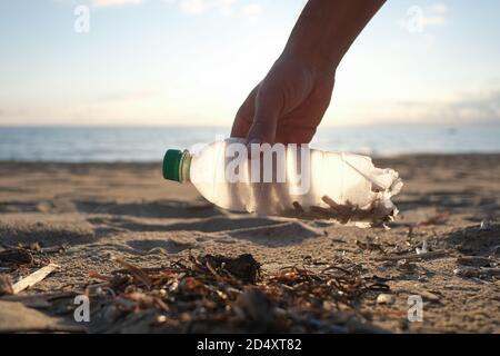 Mann Freiwillige sammeln Plastikflasche auf schmutzigen Meer Ökosystem, Umwelt kontaminiert Verschmutzung Stockfoto