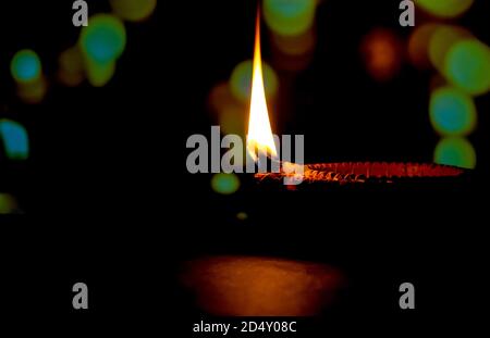 Frohes Diwali. Diya Kerze in Dipavali, hinduistisches Lichterfest beleuchtet. Traditionelle Öllampe auf dunklem Hintergrund Stockfoto