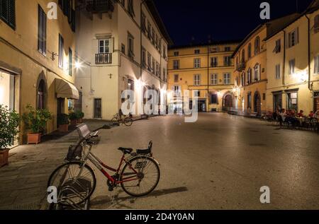 Eine Straße mit einem Café im Freien im historischen Teil von Lucca, Italien bei Nacht Stockfoto