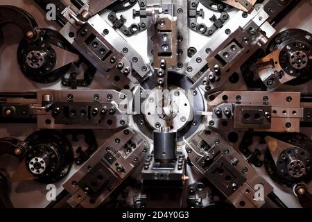 CNC-Feder, die Maschine macht. Automatische Drahtbiegemaschine. Selektiver Fokus. Stockfoto