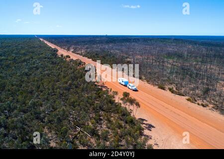 Wohnwagen, Wohnmobil, das mit dem Auto abgeschleppt wird, auf staubiger Outback-Straße, aus der Luft gesehen, Hyden Noresman Road, Western Australia Stockfoto