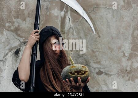 Portrait Frau Geist Dämon sie hält Schnitter und Kürbis, halloween-Konzept Stockfoto