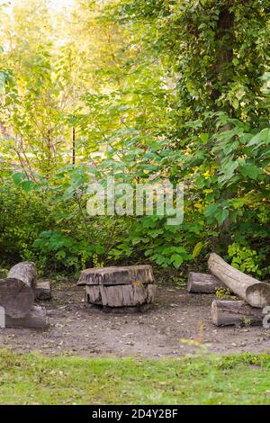 Vertikales Bild eines Baumstammes, der in Möbel verwandelt wurde Als zwei Holzbänke und ein Couchtisch im Inneren Entspannung Bereich des Parks in der Natur Stockfoto