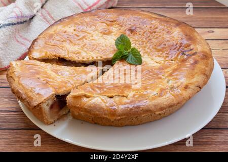 Traditionelle hausgemachte Apfelkuchen mit Preiselbeeren. Komplette Kuchen auf einem Holztisch Stockfoto