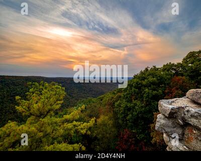 Sonnenuntergang über den Bergen von West Virginia vom Coopers Rock Overlook im Coopers Rock State Forest. Ein blauer und orangefarbener Sonnenuntergang Himmel über Herbstlaub tr Stockfoto