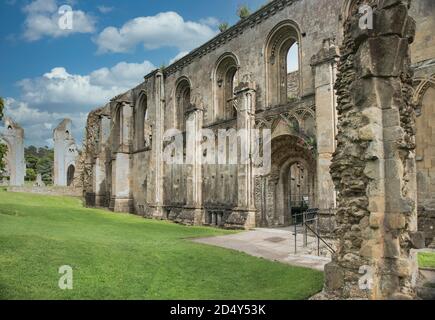 Nordwand der offenen überdachten Lady Chapel, Glastonbury Abbey Ruinen, mit dem Hauptturm unterstützt, Kreuzung und östlichen Ende in der Ferne. Krypttreppe. Stockfoto
