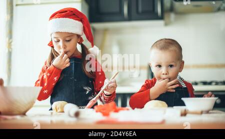 Kaukasische Bruder und Schwester, die Nahrung für die weihnachtsfeiertage vorbereiten Tragen weihnachtsmann Kleidung in der Küche Stockfoto