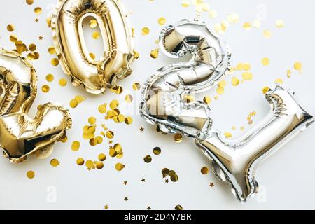 Gold und Silber Zahlen 2021 und festliche Konfetti auf weißem Hintergrund. Konzeptionelle Neujahr und Weihnachten Hintergrund. Stockfoto