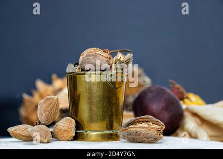 Stillleben mit Messingeimer und Mandelnüssen Nahaufnahme Unscharfer Hintergrund Stockfoto