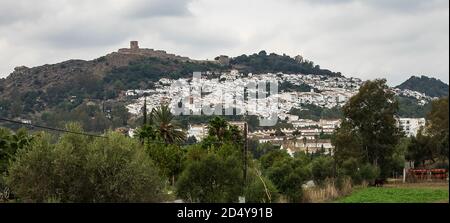 Blick auf das weiß getünchte Dorf, Pueblo Blanco und die umliegende Landschaft mit einem Schloss auf dem Hügel, Jimena de la Frontera, Provinz Cadiz, Andalu Stockfoto