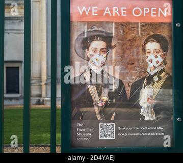 'Wir sind offen' Poster (mit Gesichtsmaske auf Menschen in einem berühmten Gemälde gesetzt) im Fitzwilliam Museum, Cambridge University, England, Oktober 2020. Stockfoto