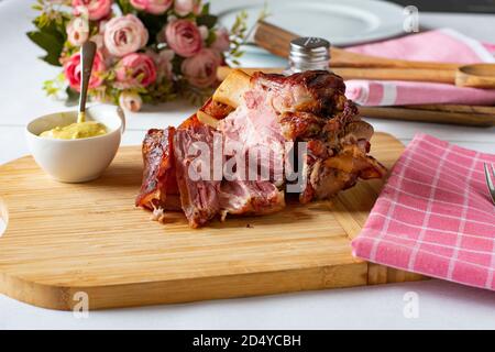 Gegrillte schweinshaxe mit Senf auf einem Holzbrett, deutsche schweinshaxe Stockfoto