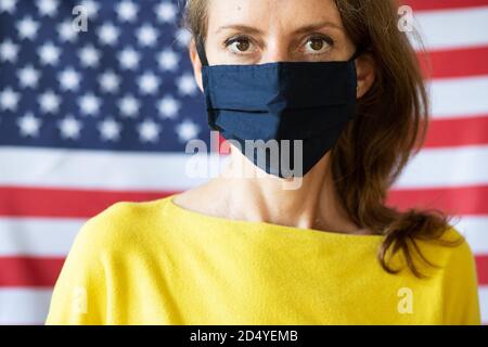 Frau trägt Maske vor den USA Flagge Wahlen während Covid Stockfoto