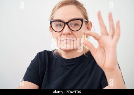 Kaukasische Frau nimmt Ergänzungen am Morgen. Vitamine, Pillen, Selbstversorgung Routine Stockfoto