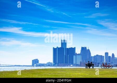 Detroit River mit Blick auf die Innenstadt und ein schönes Paar sitzen In der Bank am Sunset Point von Belle Isle Stockfoto