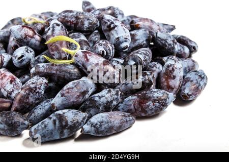 Haufen Blauer Geißblatt (Lonicera caerulea) oder Haskap-Beere isoliert auf weißem Hintergrund. Nahaufnahme. Stockfoto