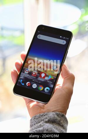 Nahaufnahme einer älteren Frau, die ein Vodafone-Mobiltelefon mit Apps hält. Stockfoto