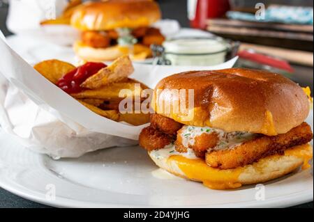 Fastfood-Mahlzeit mit Fisch Burger pommes Frites und tatar Soße Stockfoto
