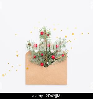 Grüner Weihnachtsbaum Symbol in Handwerk Papierumschlag, Konfetti auf weißem Kopie Raum Hintergrund. Stockfoto