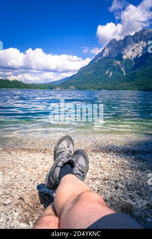 Füße mit Wanderschuhen am Ufer des Eibsee In Bayern Deutschland Stockfoto