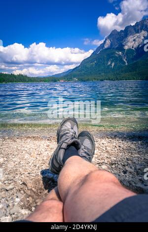 Füße mit Wanderschuhen am Ufer des Eibsee In Bayern Deutschland Stockfoto