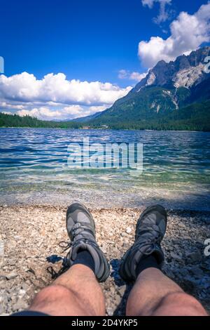Füße mit Wanderschuhen am Ufer des Eibsee In Bayern Deutschland Stockfoto