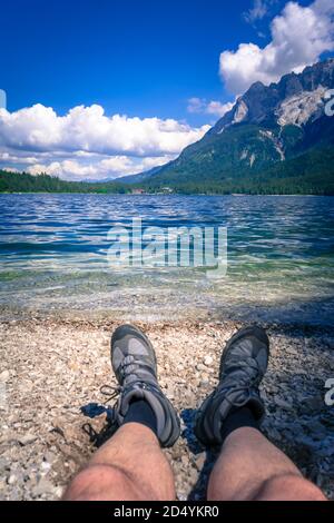 Füße mit Wanderschuhen am Ufer des Eibsee In Bayern Deutschland Stockfoto