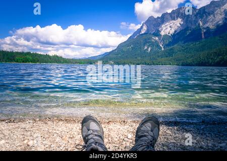 Füße mit Wanderschuhen am Ufer des Eibsee In Bayern Deutschland Stockfoto