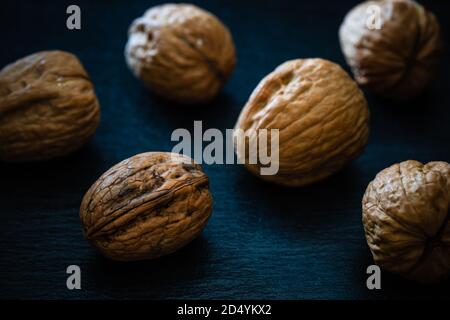 Walnüsse auf schwarzem Hintergrund - dunkle Food-Fotografie Stockfoto