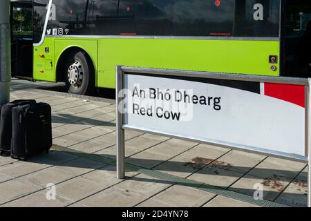 Red Cow Schild oder Beschilderung zwei Koffer und Green Bus von Dublin Coach geparkt an der Red Cow Luas Haltestelle in Dublin, Irland als Reise-und Pendelkonzept Stockfoto