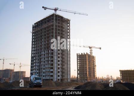 Schwere Mischer Betonwagen wartet auf Beton auf einer Baustelle geladen werden. Turmdrehkrane bauen ein neues Wohngebäude. Stockfoto