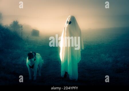 halloween Geist mit Hund in nebliger Landschaft Stockfoto