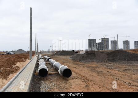 Gusseiserne Kanalrohre für die Verlegung einer externen Abwasseranlage auf einer Baustelle. Sanitäre Entwässerung für ein mehrstöckiges Gebäude. Zivile Infrastruktur Stockfoto