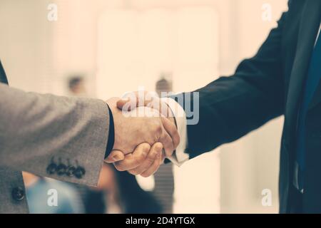 Firm Business Handshake auf einem verschwommenen Bürohintergrund. Stockfoto