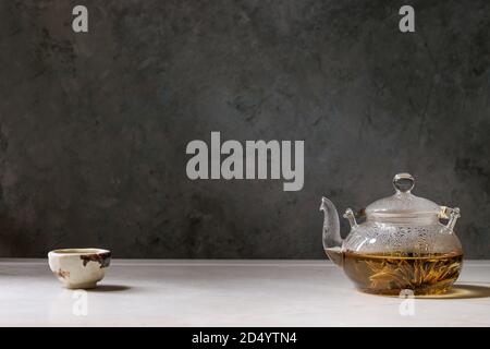 Hot grüner Tee in der traditionellen chinesischen Ton Keramik Tasse und Glas Teekanne auf weißem Marmor tisch. Stockfoto