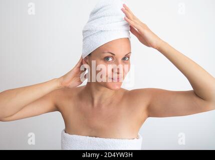 Kaukasische Frau mit Kopf und Körper in weißen Handtüchern eingewickelt. Stockfoto