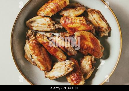 BBQ spicy Chicken Wings in Keramik Platte über weißem Marmor Hintergrund serviert. Flach, Platz. Stockfoto