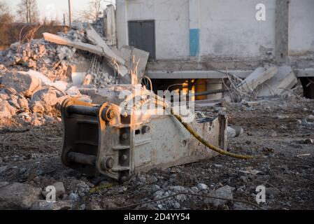Hydraulikhammer für die Zerstörung von Beton und Hartgestein auf der Baustelle. Bagger auf Sonnenuntergang Hintergrund. Presslufthammer mit für Stockfoto