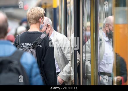 Stuttgart, Deutschland. Oktober 2020. Passanten mit Mund- und Nasenschutz steigen in eine U-Bahn. In Stuttgart wurde am Samstag der Warnwert von 50 Neuinfektionen pro 100,000 Einwohner in sieben Tagen überschritten. Quelle: Sebastian Gollnow/dpa/Alamy Live News Stockfoto