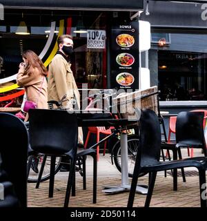 London UK Oktober 10 2020, zwei Personen gehen eins mit COVID-19 Gesichtsbedeckung, einer ohne Stockfoto