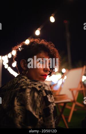 ALICANTE, SPANIEN - 01. Okt 2020: Frauenportrait mit Glühbirnen Hintergrund Stockfoto