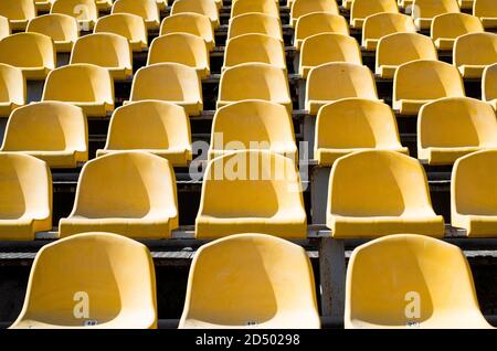 Leere gelbe Sitze auf Outdoor-Sportstadion Arena für Fußballfans, großes Spiel. Stockfoto