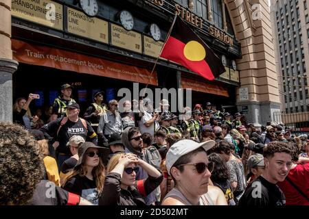 Während der Demonstration blicken die Demonstranten auf den Bahnhof Flinders Street.Tausende von Menschen sind in Melbourne auf die Straßen gegangen, um gegen die nationale Feier des Australia Day zu protestieren. Der 26. Januar, der den Aborigines als „Invasion Day“ bekannt ist, bezeichnet den Tag, an dem Australien 1788 offiziell kolonisiert wurde und seit 1994 ein nationaler Feiertag und Feiertag ist. Stockfoto