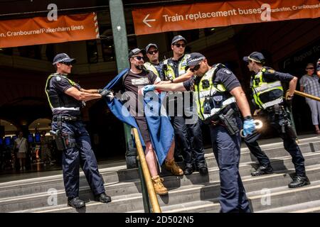 Mitglieder der Victoria Police verhaften Neil Erikson, einen rechtsextremen Extremisten am Bahnhof der Flinders Street während der Demonstration.Tausende von Menschen sind in Melbourne auf die Straßen gegangen, um gegen die nationale Feier des Australia Day zu protestieren. Der 26. Januar, der den Aborigines als „Invasion Day“ bekannt ist, bezeichnet den Tag, an dem Australien 1788 offiziell kolonisiert wurde und seit 1994 ein nationaler Feiertag und Feiertag ist. Stockfoto