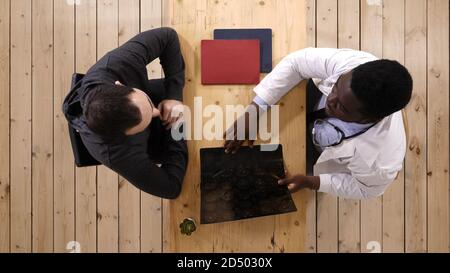 Junge afrikanische amerikanische Arzt Beratung mit Patienten. Stockfoto