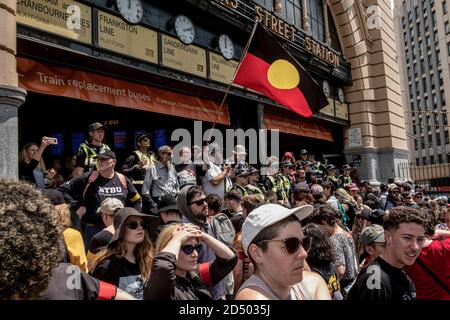 Melbourne, Australien. Januar 2020. Während der Demonstration blicken die Demonstranten auf den Bahnhof Flinders Street.Tausende von Menschen sind in Melbourne auf die Straßen gegangen, um gegen die nationale Feier des Australia Day zu protestieren. Der 26. Januar ist für die Aborigines als „Invasion Day“ bekannt und bezeichnet den Tag, an dem Australien 1788 offiziell kolonisiert wurde. Seit 1994 ist er ein nationaler Feiertag und ein Feiertag. Kredit: Diego Fedele/SOPA Images/ZUMA Wire/Alamy Live Nachrichten Stockfoto