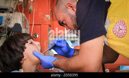 Krankenschwester umarmt ein Kind und behandelt es im Krankenwagen. Stockfoto