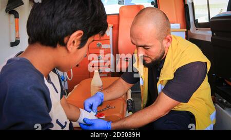 Krankenschwester umarmt ein Kind und behandelt es im Krankenwagen. Stockfoto