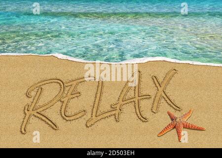 Wort Relax geschrieben am Strand Stockfoto